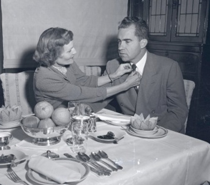 17. Straightening her husband's tie at dinner, on the campaign trail in 1956.
