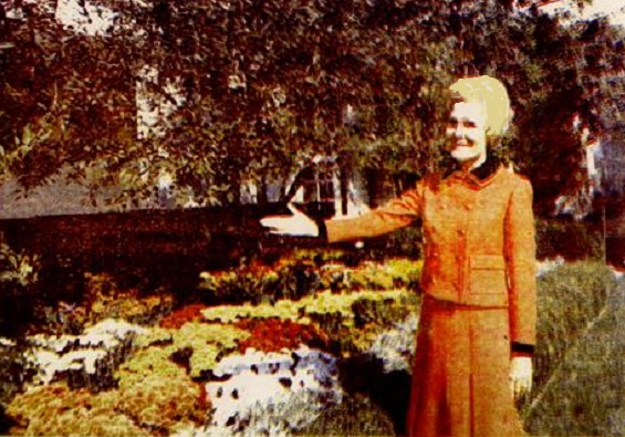 40. A colorized newswire service photo of Mrs. Nixon showing off the fall flowers of the White House gardens; she initiated the first public tours of the grounds in the spring and fall.
