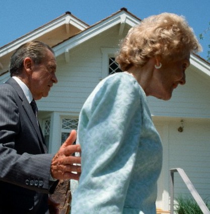 98. Gently guided by her husband, Pat Nixon is about to visit his restored childhood home on the grounds of his presidential library, 1990.
