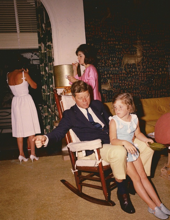 Easter Sunday 1963. President Kennedy sits with his daughter while Jackie Kennedy steals a smoke behhind them.