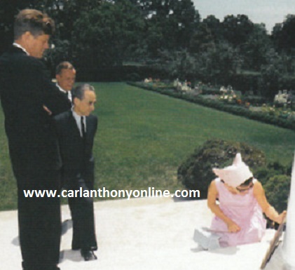Jackie Kennedy examines a bronze work on steps outside the Rose Garden as President Kennedy and an art dealer look on. JFK went to great lengths to get her a piece of art for Christmas she loved.