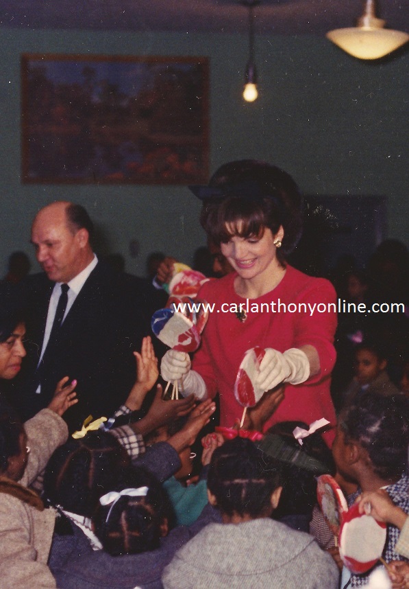 Jacqueline Kennedy handing out lollipops during her holiday visit to Junior Village, December 1961.