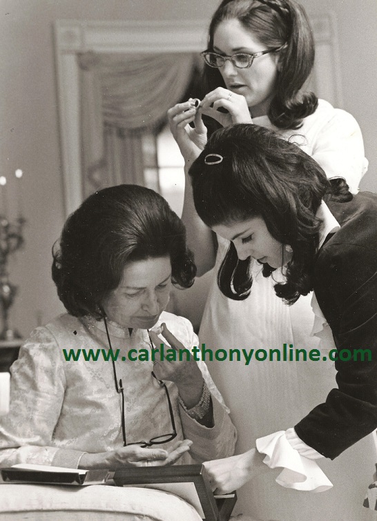 Lady Bird Johnson and her daughters Lynda and Luci sample a CHristmas present of some candy sent to them.