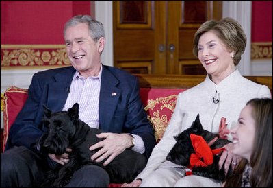 The Bushes hold their Scottie dogs Barney and Miss Bezley, their daughter Barbara sits at right.