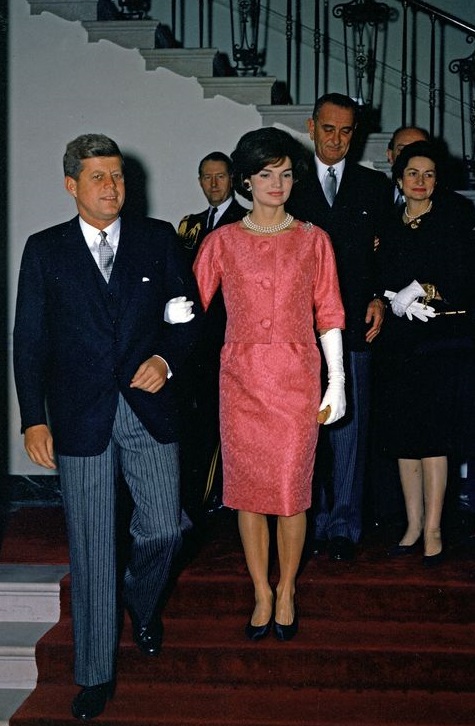The Kennedys and the LBJs descend the White House grand staircase to host a White House reception.