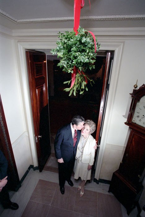 The Reagans kiss under the mistletoe.