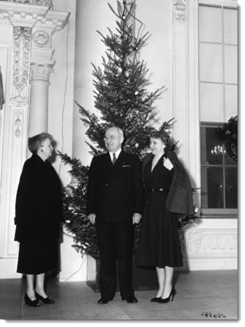 The Trumans with one of the two Christmas trees on the North Portico during their last holiday season in the White House, 1952.