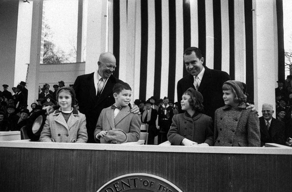 In the 1957 Inaugural Parade reviewing stand, President Eisenhower's grandson David sets his sight on Vice President Nixon's daughter Julie.