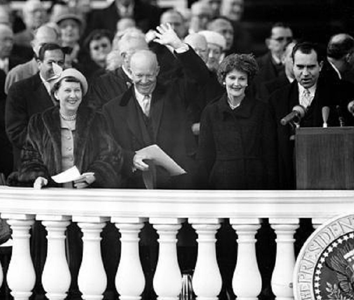 The Eisenhowers and Nixons acknowledge a cheer from the crowds on the 1957 Inaugural ceremony stand.